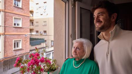 María Luisa Martínez y su nieto mayor, Miguel Alfaro, observan la calle Joaquín Larregla de La Milagrosa desde la ventana de ella