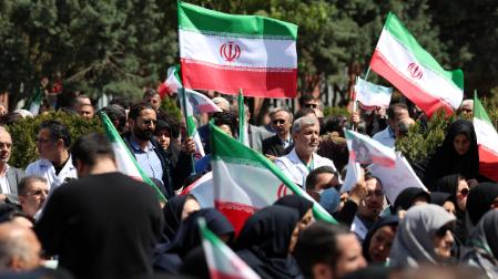 Miembros del personal sanitario iraní, portando banderas iraníes, participan en una protesta contra los ataques estadounidenses e israelíes contra instalaciones sanitarias en el Hospital Imam Khomeini de Teherán, Irán