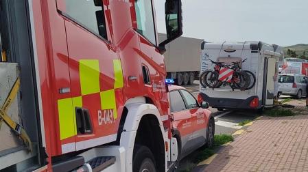 Servicios de emergencia junto a la autocaravana y el vehículo accidentados