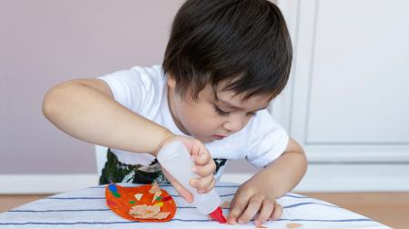 Un niño jugando con pegamento