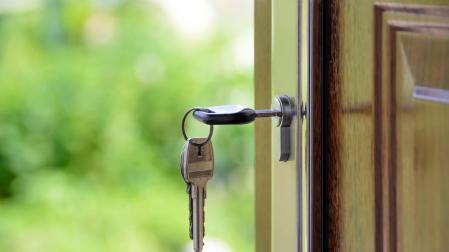 Keys and lock the door on the background of solar garden Keys to your own homeLLAVES PUESTAS EN UNA PUERTA.