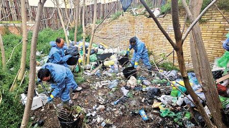Operarios de la brigada municipal retiran la basura del solar durante la mañana de este jueves, 9 de abril