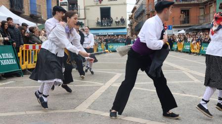 Una danzari de Mendianike intenta quemar el plego al compañero que lleva delante