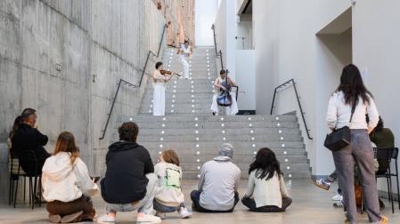 El público escucha a Kana Sugimura y Martha Bijlsma, intérpretes de la parte musical, a quienes acompaña la bailarina Emilia Benítez.