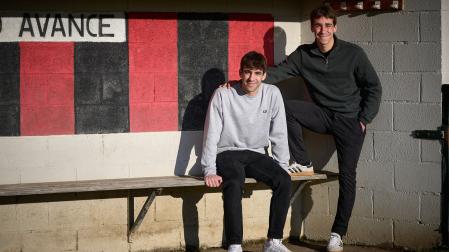 Marcos Agramonte, sentado, junto a su hermano Iñigo, de pie, en el banquillo local de Igeldea en Arre.