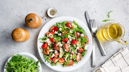 Healthy vegetable salad with arugula, tomatoes and goats cheese