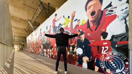 El artista LKN, delante del mural instalado en la zona de grada Lateral de El Sadar.