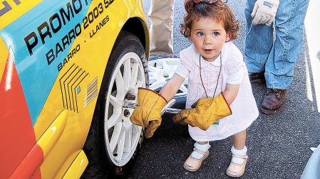 Marina, de pequeña, emulando un cambio de ruedas en el coche