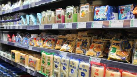 Una estantería de quesos de un supermercado