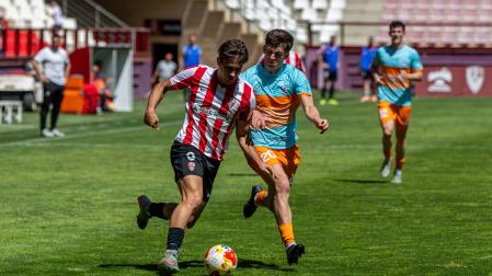 Albert Rosas, de la U.D.Logroñés, conduce el balón ante la presión de Xabier Roldán, de la Mutilvera