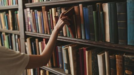 Una persona extrae un ejemplar de una librería