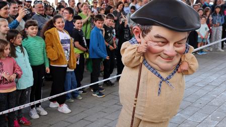 El cabezudo 'Juantramposo' pasa por delante de un grupo de menores durante su presentación.