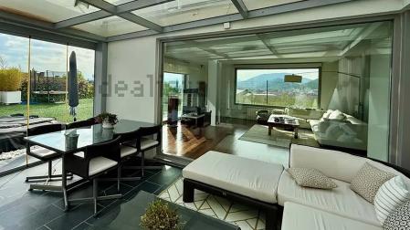 Zona de porche cubierto con el salón al otro lado de la cristalera