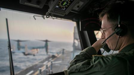 Un oficial naval a bordo del USS Tripoli supervisa las operaciones de vuelo desde la torre de control mientras el buque de asalto anfibio navega en el mar Arábigo