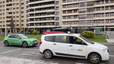 Un vehículo de la plataforma Bolt circula junto a una parada de taxi en Pamplona