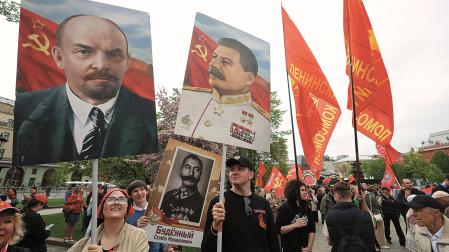 Un grupo de rusos exhibe los retratos de Putin y Stalin, ayer, en el primer día de la celebración en Moscú