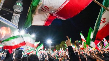 Partidarios del gobierno iraní ondean banderas nacionales durante una manifestación