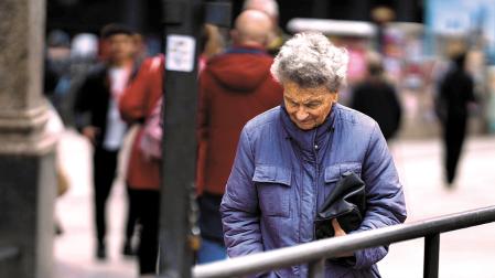 Una pensionista pasea por las calles de Madrid