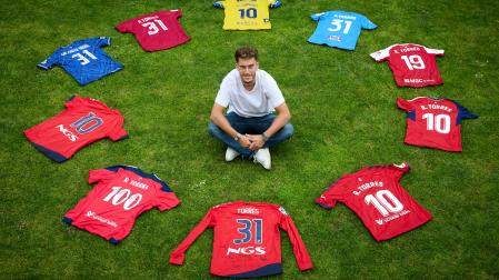 Roberto Torres posa en Arre con camisetas representativas de su carrera:la del filial, la del debut, la de los dos ascensos, la última con Osasuna y las de los cinco equipos posteriores, Foolad, Gol Gohar, Inter Escaldes, Nástic y Orihuela.