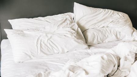 Una cama sin hacer con las sábanas revueltas