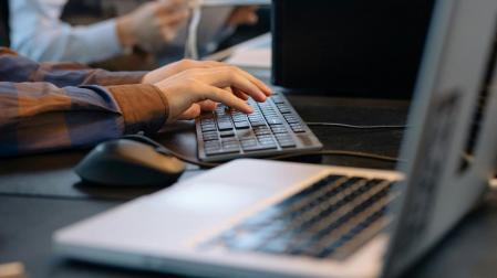 Una persona trabajando con varios ordenadores