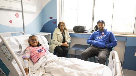 Edurne Rodríguez, en la cama de la Unidad del Paciente Crónico Complejo Pediátrico del HUN, con sus padres José y Deuzenete