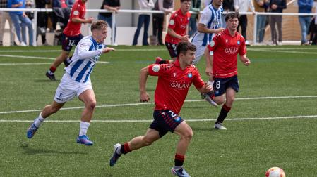 El centrocampista del Subiza Xabi Garín sale con el balón perseguido por Oier Aierdi, central del Izarra