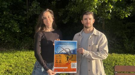 Clara Ilundáin y Guillermo Urmeneta, voluntarios de Caravana de Vida, con el cartel de la nueva edición