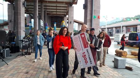 Imagen de una edición anterior de la fiesta de pentecostés en Dantxarinea, con la entrega del cheque de 1.500 euros al ganador del sorteo por parte del presidente de la Asociación de Comerciantes, Txomin Iriarte.