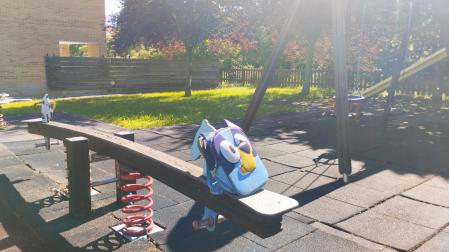 Una solitaria mochila escolar, en un parque infantil sin niños