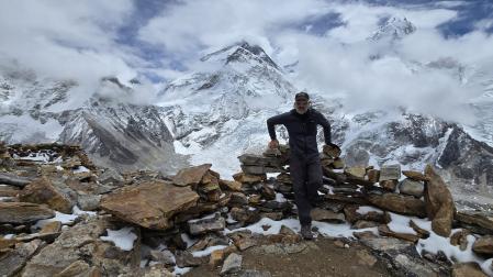 Óscar Arroyo Úbeda, con la cumbre del Everest a su espalda asomando entre las nubes