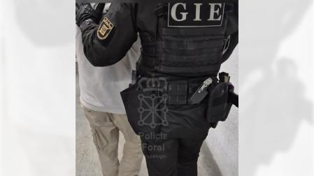 Un agente de la Policía Foral conduce al detenido