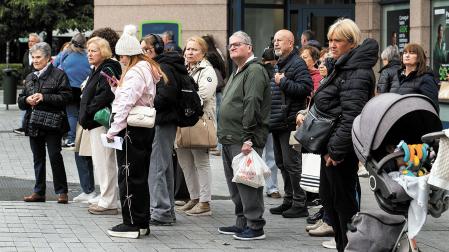 Un grupo de ciudadanos espera la villavesa en una plaza de Pamplona