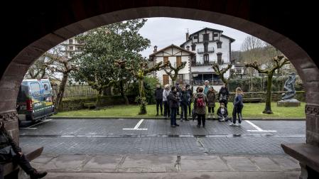 Un grupo de visitantes atiende las explicaciones de una guía del circuito de 'La Trilogía del Baztan'.