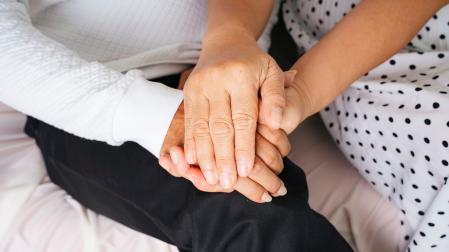 Close up - Old elderly senior couple holding hands with care and promise.