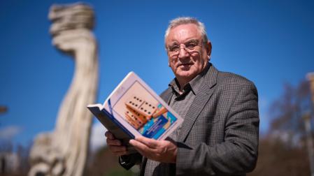 José A. Gurpegui posa con su libro en Pamplona delante de la escultura ‘Tramontana’, nombre que se da al viento frío y violento que sopla del norte o noroeste en el Mediterráneo occidental, y con el que se alude metafóricamente al cambio brusco que Trump está infringiendo al orden mundial.