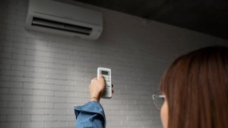Una persona encendiendo el aire acondicionado en su casa