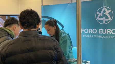 Dos jóvenes se acercan a un estand de Foro Europeo para obtener información sobre su oferta formativa