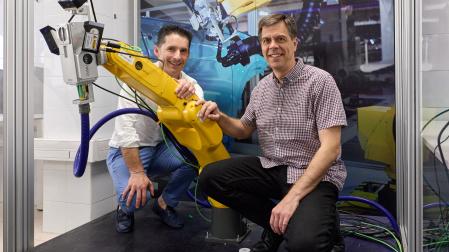 Eduardo Azanza e Israel Arnedo posan con un robot equipado con el cabezal que permite medir el espesor de la pintura