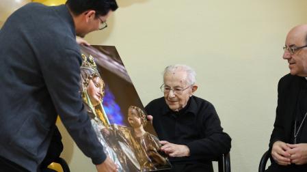Jesús Labiano recibe una imagen de la virgen del Roncesvalles de manos del sacerdote Carlos Martínez y junto al arzobispo de Pamplona, Florencio Roselló.
