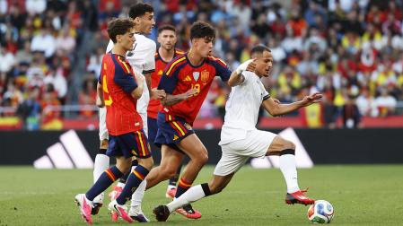 Marc Bernal, junto a Gavi, persigue al iraquí Ali Al Hamadi durante el partido