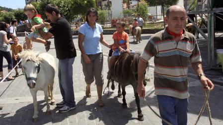 Dos menores pasean sobre sendas pottokas en una feria de Bera.