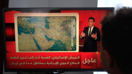 Una persona observa una transmisión televisiva sobre los últimos acontecimientos en el conflicto de Oriente Medio tras el ataque con misiles de los hutíes contra Israel en Saná, Yemen