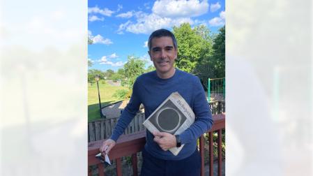 Iñaki Ugarte Urra lleva en sus manos las gafas con las que vio el eclipse del 21 de agosto de 2017 desde Carolina del Sur y la portada del New York Times del día siguiente
