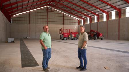 Francisco Javier Artajo Carlos (izda.) y José Luis Pemán Calvo, presidente y gerente de la Sociedad Cooperativa Cerealista de Sangüesa, dentro de la nueva nave de almacenamiento de cereal en construcción