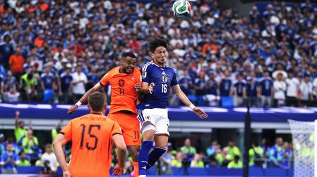 Cody Gakpo (izda.) de Países Bajos disputa el balón con Tsuyoshi Watanabe (dcha.) de Japón