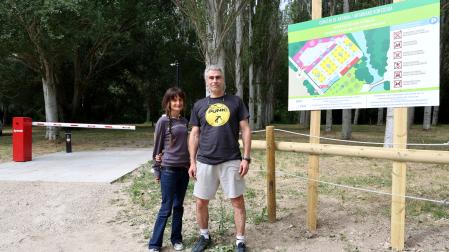 El presidente del concejo, Óscar Oliván, y Gemma Martínez, compañera de junta, en la zona de acceso al parking con el nuevo sistema de barreras.