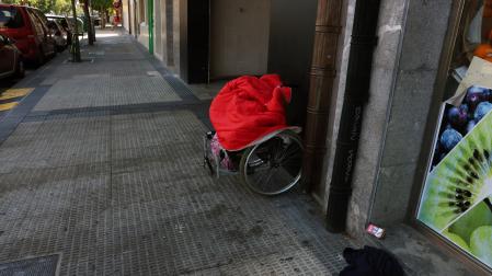 Silla de ruedas que utilizaba M. para pedir, este martes por la mañana en el lugar donde fue apuñalado el lunes.