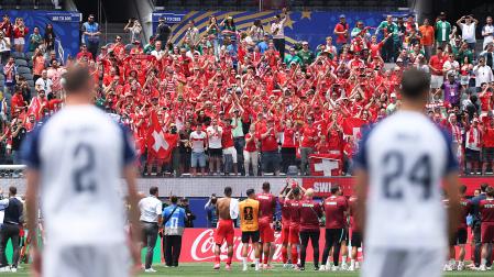 Los jugadores suizos celebran con su afición la victoria ante la desolación de los bosnios