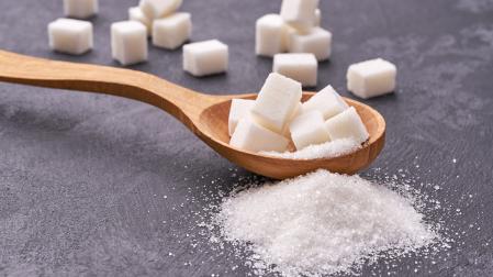 white sugar in wood spoon on black table,selective focus